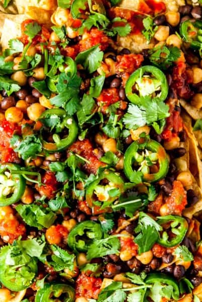 The ultimate vegan nachos, loaded with black beans, spicy chickpeas, and all your favorite toppings! These are a winner for your next party, potluck, or family dinner.